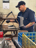man spot welding an autoclave stainless steel sterilization basket